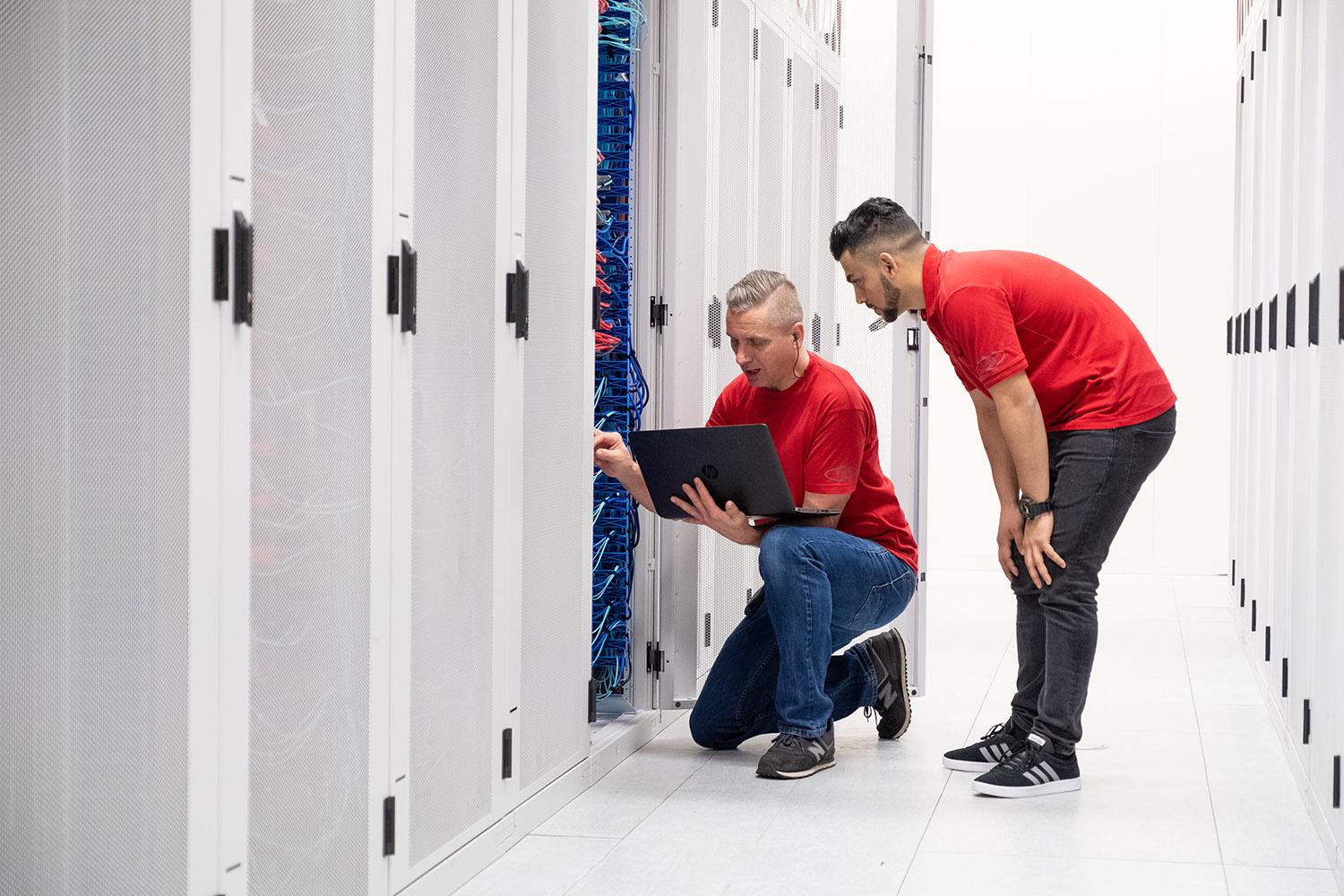 Twee mensen aan het werk in een server ruimte